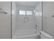A tiled tub and shower combination with window at 8228 Lauderdale Ct, Las Vegas, NV 89128