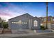 Inviting single-story home with a well-manicured front yard and two-car garage at 8228 Lauderdale Ct, Las Vegas, NV 89128