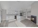 Bright kitchen with white cabinets, stainless appliances, a quartz island, and fireplace at 8228 Lauderdale Ct, Las Vegas, NV 89128