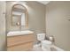 Contemporary powder room with a light wood vanity, arched mirror, modern fixtures, and tiled floors at 8255 Las Vegas Blvd # 1422, Las Vegas, NV 89123