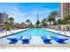 Enjoy the community pool with in-water lounge chairs on a sunny day near palm trees and modern high-rise buildings at 8255 Las Vegas Blvd # 1422, Las Vegas, NV 89123