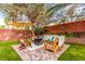 The backyard features a cozy patio with outdoor seating, string lights, and a serene ambiance at 905 Possum Hill St, Henderson, NV 89014