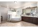 Bright bathroom with tiled floors, large soaking tub, vanity, and a decorative mirror at 905 Possum Hill St, Henderson, NV 89014
