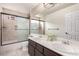Bathroom featuring double sinks, tile flooring, and a shower with glass doors at 905 Possum Hill St, Henderson, NV 89014