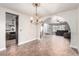 Open dining room with chandelier flowing into living room and kitchen with tile flooring throughout at 905 Possum Hill St, Henderson, NV 89014