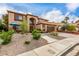 Charming two-story home featuring a well-manicured front yard with lush landscaping, concrete walkway, and a two-car garage at 905 Possum Hill St, Henderson, NV 89014