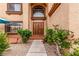 Beautiful entryway showing the double front doors framed by manicured bushes and an arched window at 905 Possum Hill St, Henderson, NV 89014