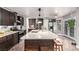 Bright kitchen featuring a large island with a sink, modern lighting, and a stainless steel refrigerator at 905 Possum Hill St, Henderson, NV 89014