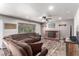 Cozy living room with a brick fireplace, ceiling fan, wood-look floors and large sectional sofa at 905 Possum Hill St, Henderson, NV 89014