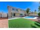 Spacious backyard featuring a pool, covered patio, and artificial turf at 9541 Summersweet Ct, Las Vegas, NV 89123