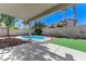Inviting backyard featuring a refreshing pool, patio, and artificial turf for relaxation and entertainment at 9541 Summersweet Ct, Las Vegas, NV 89123