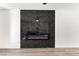 Living room electric fireplace with black marble surround and gray wood-look floors at 9541 Summersweet Ct, Las Vegas, NV 89123