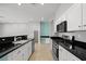Bright kitchen featuring stainless steel appliances, black countertop and white cabinets at 9624 Twelve Pins Dr, Las Vegas, NV 89129