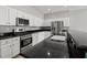Bright kitchen featuring stainless steel appliances, black countertop and white cabinets at 9624 Twelve Pins Dr, Las Vegas, NV 89129
