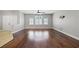 Hardwood flooring in an open floor plan living room with multiple pane windows, ceiling fan and neutral walls at 9624 Twelve Pins Dr, Las Vegas, NV 89129