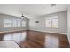 Open living area with hardwood floors, neutral walls, ceiling fan, and large windows with horizontal blinds at 9624 Twelve Pins Dr, Las Vegas, NV 89129
