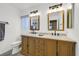 Bathroom with granite vanity featuring dual sinks and a decorative lighting fixture at 9815 Ramhorn Canyon St, Las Vegas, NV 89183
