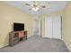 Neutral bedroom features ceiling fan, and a storage unit below the TV at 9815 Ramhorn Canyon St, Las Vegas, NV 89183
