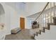 Bright foyer featuring tile flooring, an open staircase, a high ceiling, and a decorative bench at 9815 Ramhorn Canyon St, Las Vegas, NV 89183