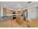 Well-lit kitchen featuring wooden cabinets, a stainless-steel refrigerator, granite countertops, and a central island at 9815 Ramhorn Canyon St, Las Vegas, NV 89183