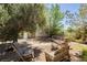 Relaxing backyard seating area shaded by mature trees, perfect for unwinding in a peaceful outdoor setting at 997 N Christy Ln, Las Vegas, NV 89110