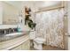Cozy bathroom features a single sink vanity with granite countertop and tiled shower with decorative floral curtain at 997 N Christy Ln, Las Vegas, NV 89110