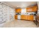 Functional kitchen featuring wood cabinets, tile floor, and a stainless steel dishwasher at 997 N Christy Ln, Las Vegas, NV 89110