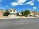 Inviting two-story home features lush landscaping, a well-manicured lawn, and an attached two-car garage at 1021 Calico Ridge Dr, Henderson, NV 89011