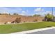 Backyard with artificial turf, stone border, concrete patio and brick wall at 10508 Waking Cloud Ave, Las Vegas, NV 89129