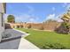 A backyard featuring a manicured lawn, concrete patio, and a brick wall fence for added privacy at 10508 Waking Cloud Ave, Las Vegas, NV 89129
