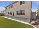 A spacious backyard featuring artificial turf, a concrete patio, and mature landscaping at 10508 Waking Cloud Ave, Las Vegas, NV 89129