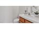 Half bathroom features a vanity with a sink, toilet, and neutral decor at 10508 Waking Cloud Ave, Las Vegas, NV 89129
