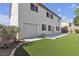 The exterior of the home shows the backyard, grass and an attached garage at 10508 Waking Cloud Ave, Las Vegas, NV 89129
