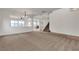 Spacious living area with neutral carpet, open layout, and staircase at 10508 Waking Cloud Ave, Las Vegas, NV 89129