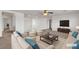 Spacious living room with plush seating, neutral tones, and a ceiling fan at 10508 Waking Cloud Ave, Las Vegas, NV 89129