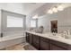 Bathroom with double vanity, a large mirror and bathtub at 1105 Strada Pecei, Henderson, NV 89011