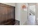 Inviting entryway with a wooden bench and coat rack, leading to an open staircase at 1105 Strada Pecei, Henderson, NV 89011
