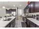 Modern kitchen boasts stainless steel appliances, dark wood cabinetry, and a spacious island with a sink at 1105 Strada Pecei, Henderson, NV 89011