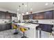 Modern kitchen with dark cabinetry, a center island with seating, and stainless steel appliances at 1105 Strada Pecei, Henderson, NV 89011