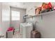 Practical laundry room with a washer, dryer, storage shelves, and natural light at 1105 Strada Pecei, Henderson, NV 89011