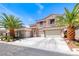 Stunning two-story stucco home featuring a three-car garage, beautiful stonework, and mature landscaping at 11275 Gammila Dr, Las Vegas, NV 89141