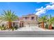 Charming stucco home with tile roof, three-car garage, and lush landscaping featuring mature palm trees at 11275 Gammila Dr, Las Vegas, NV 89141