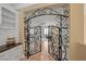 View of the gym through an ornamental metalwork gate, with hardwood floors and fitness equipment at 11275 Gammila Dr, Las Vegas, NV 89141