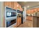 Well-equipped kitchen with double ovens, stainless steel appliances, and traditional wood cabinets at 11275 Gammila Dr, Las Vegas, NV 89141