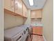 Functional laundry room with modern washer and dryer, tile flooring, and built-in cabinets at 11275 Gammila Dr, Las Vegas, NV 89141
