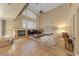 Bright living room with fireplace, large windows, and soaring ceilings provides warmth and natural light at 11275 Gammila Dr, Las Vegas, NV 89141