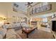 Bright living room featuring vaulted ceilings, a fireplace, and an open layout connecting to the kitchen at 11275 Gammila Dr, Las Vegas, NV 89141