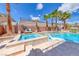 Lush backyard featuring a modern pool, spa, lounge chairs, and tropical palm trees at 11275 Gammila Dr, Las Vegas, NV 89141