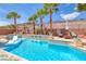 Resort-style pool with tanning ledge, lush palm trees, and comfortable lounge seating offers a private outdoor retreat at 11275 Gammila Dr, Las Vegas, NV 89141