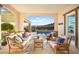 Covered patio with comfortable seating overlooking the pool and landscape at 12217 Tempestad Ave, Las Vegas, NV 89138